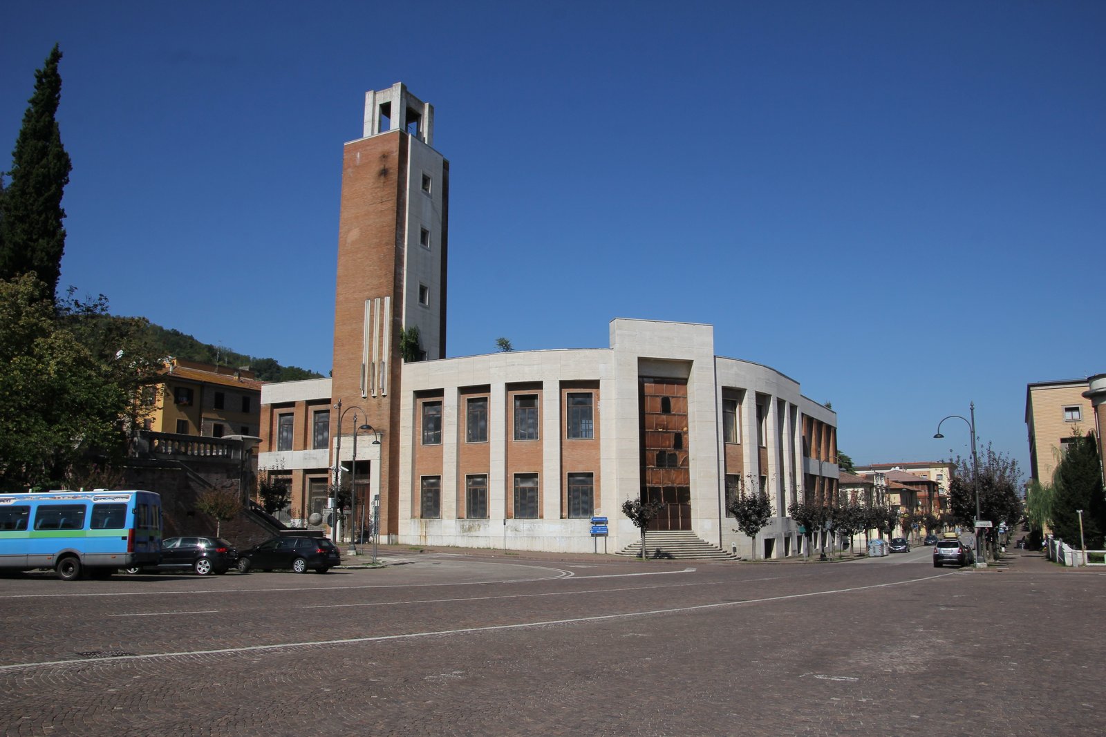 The travertine and brick facade of the former Casa del Fascio in Predappio, with its tall littorio tower